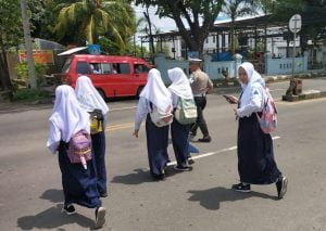 Wujud Kepedulian Pada Masyarakat, Polantas Bantu Anak Sekolah Menyebrang Jalan